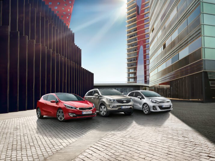 Drei Autos in städtischer Umgebung, mit modernen Gebäuden und einer sonnigen Atmosphäre im Hintergrund.