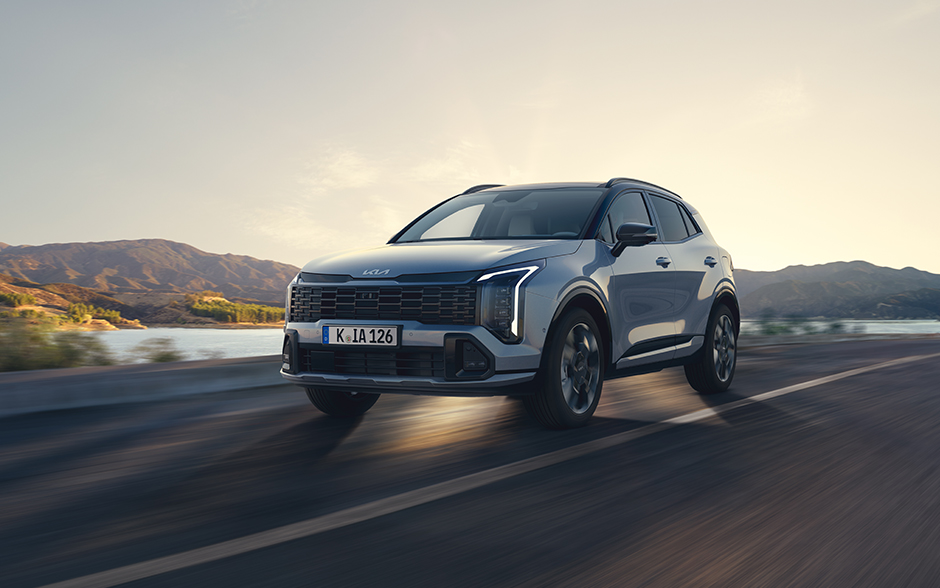 Kia EV4 Fastback in einer urbanen Umgebung, präsentiert mit einer stilvollen Person neben dem Auto.